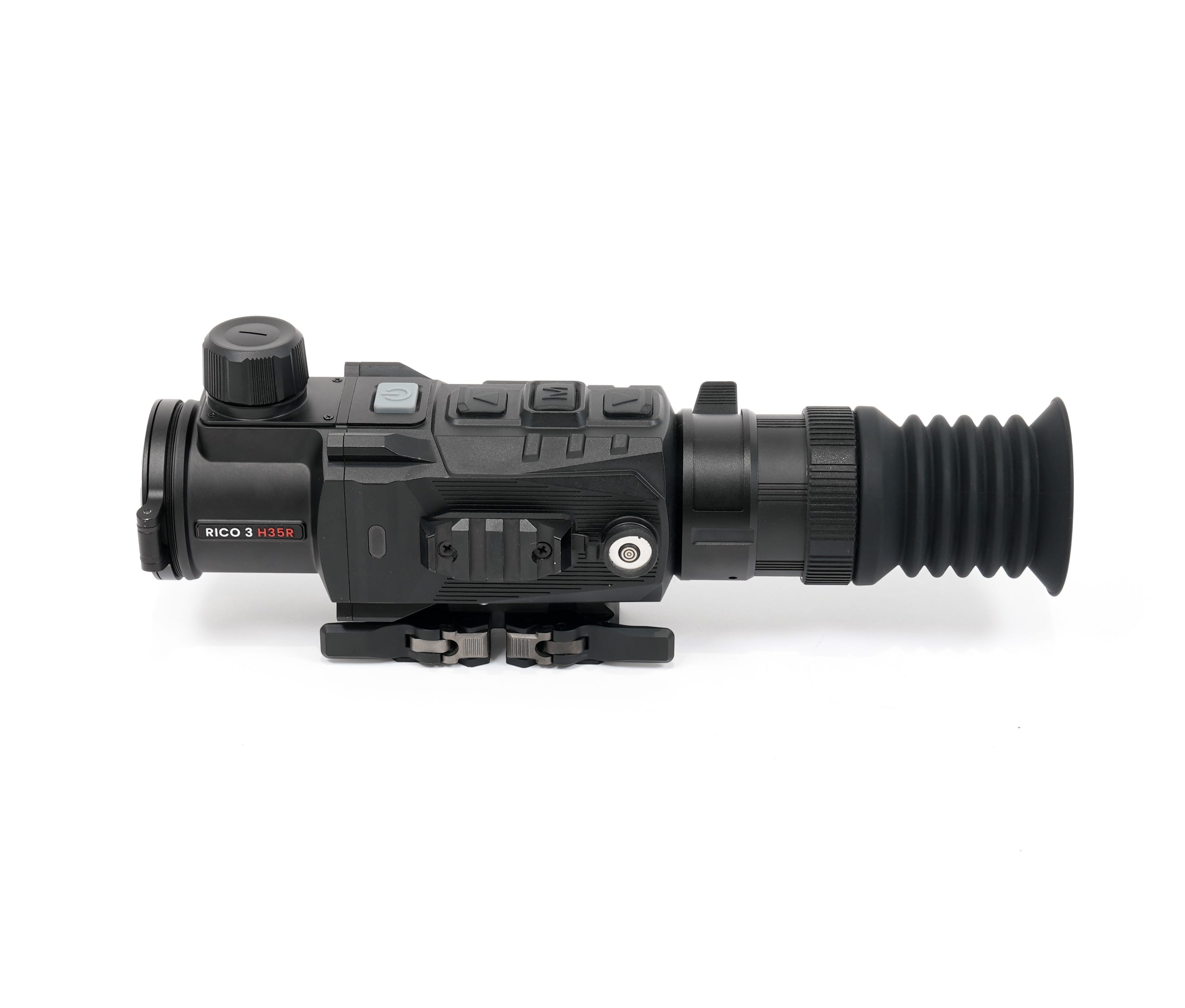 Close-up of a black rifle scope with a large top dial, labeled RICO 3 H35R on the side.