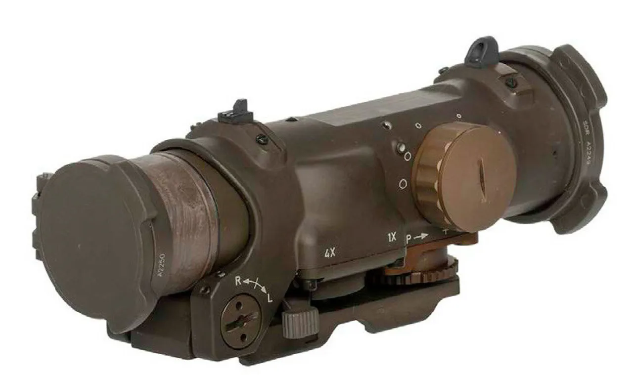 Military-style rifle scope with multiple adjustment dials and a sunshade, designed for precision aiming at distance, mounted on a rail system.