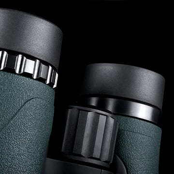 Close-up of the eyepieces and focus wheel on a green-and-black binoculars, showing textured body and adjustment knobs.