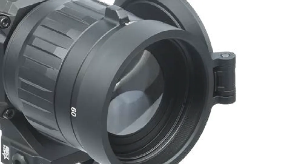 Close-up of a large black camera lens with focus rings and a '60' marking visible on the barrel