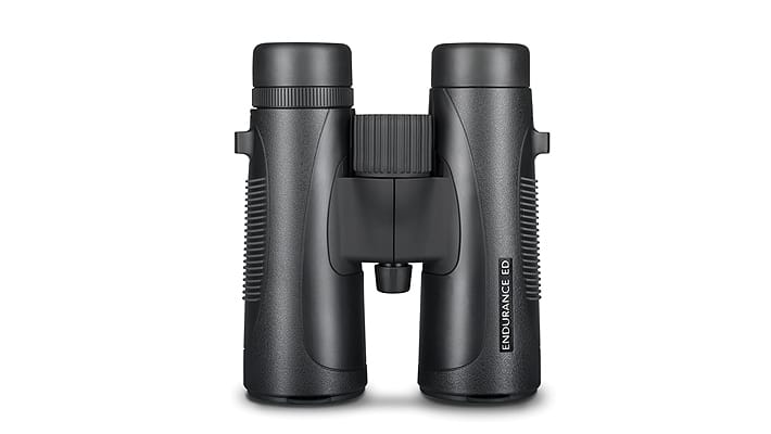 Black binoculars viewed from the front, close-up on the central hinge and eyepieces, labeled 'ENDURANCE' on the right leg