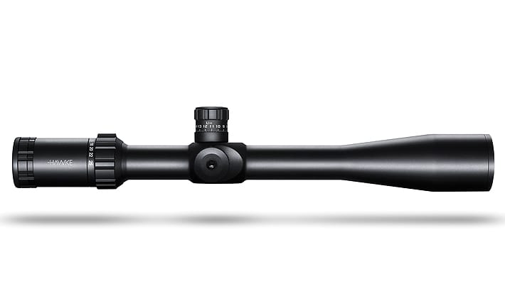 Black rifle scope with adjustment turrets, laid horizontally against a white background