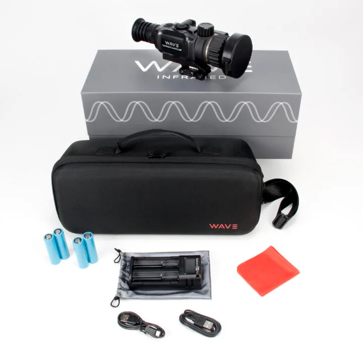 Infrared aimscope with carrying case, batteries, charger, cables, and red microfiber cloth laid out beside the box and bag.